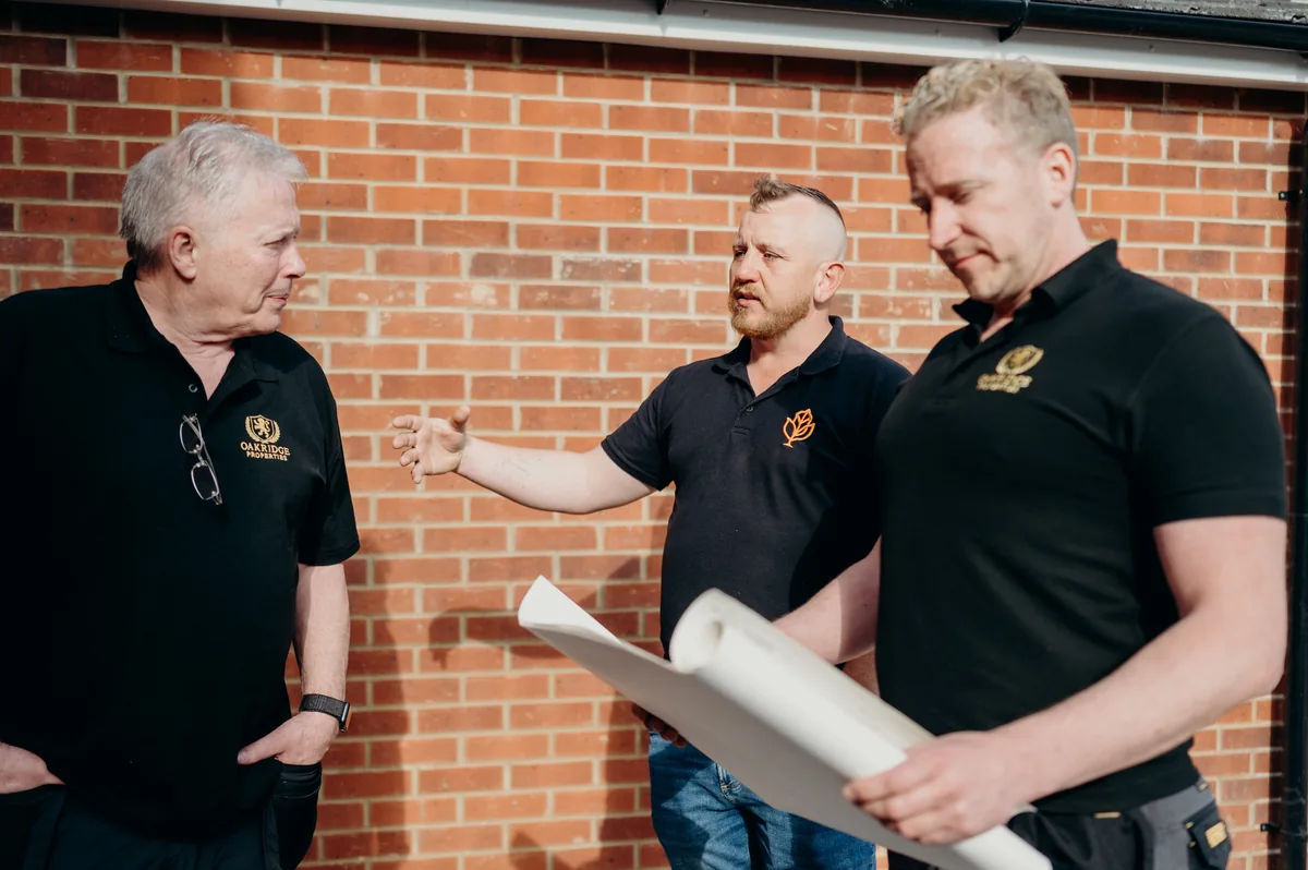 Mike, Davey and Simon reviewing plans together outside a refurbishment